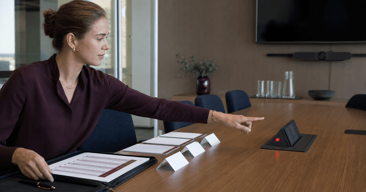 Executive assistant reviewing recording controls before a conference-room meeting